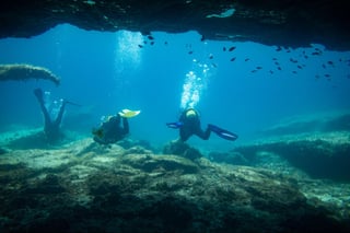 Divers comes out of an underwater cave